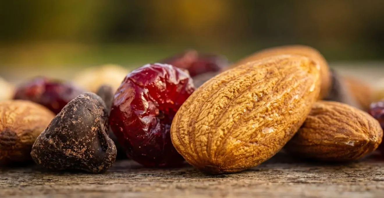 Extreme close-up macro shot of trail mix components showing texture of almonds and dried fruits