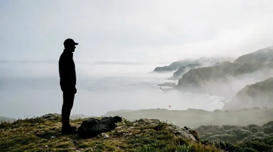 Professional golfer selecting club while observing marine fog conditions on coastal course