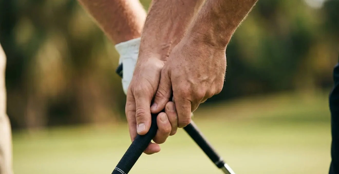 Close-up of golfer's hands gripping club with focused determination and controlled tension
