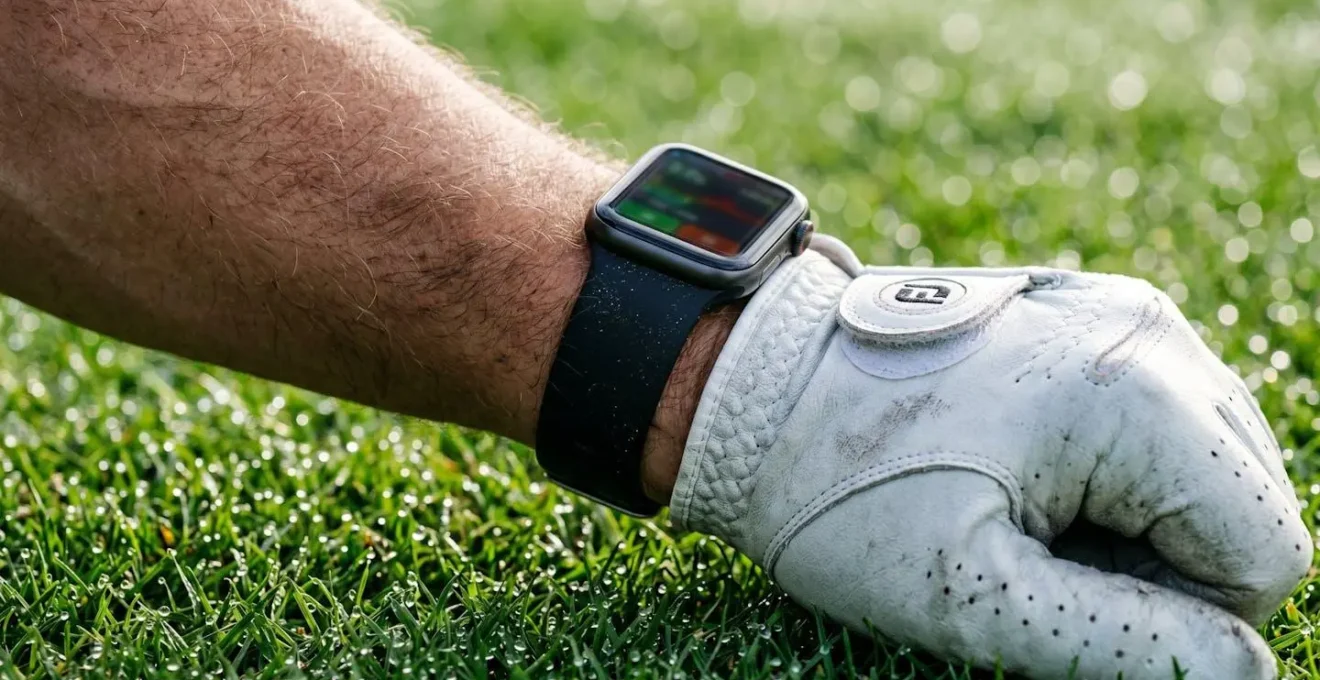 Close-up of golfer checking fitness tracker data while on putting green