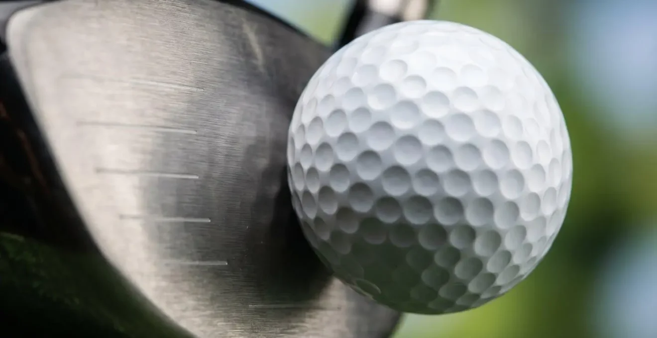 Extreme close-up of golf ball compression at moment of impact showing energy transfer