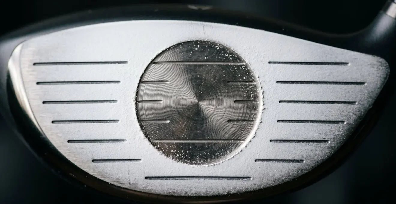 Macro detail of driver clubface showing impact feedback pattern with powder spray revealing strike location analysis